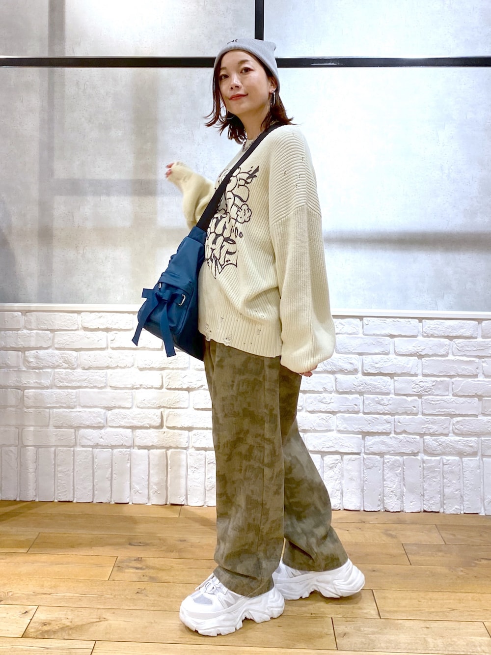ホワイト系のニット/セーター、ブルー系のショルダーバッグ、その他のデニムパンツを着用したレディースの春コーディネートの7枚目の写真