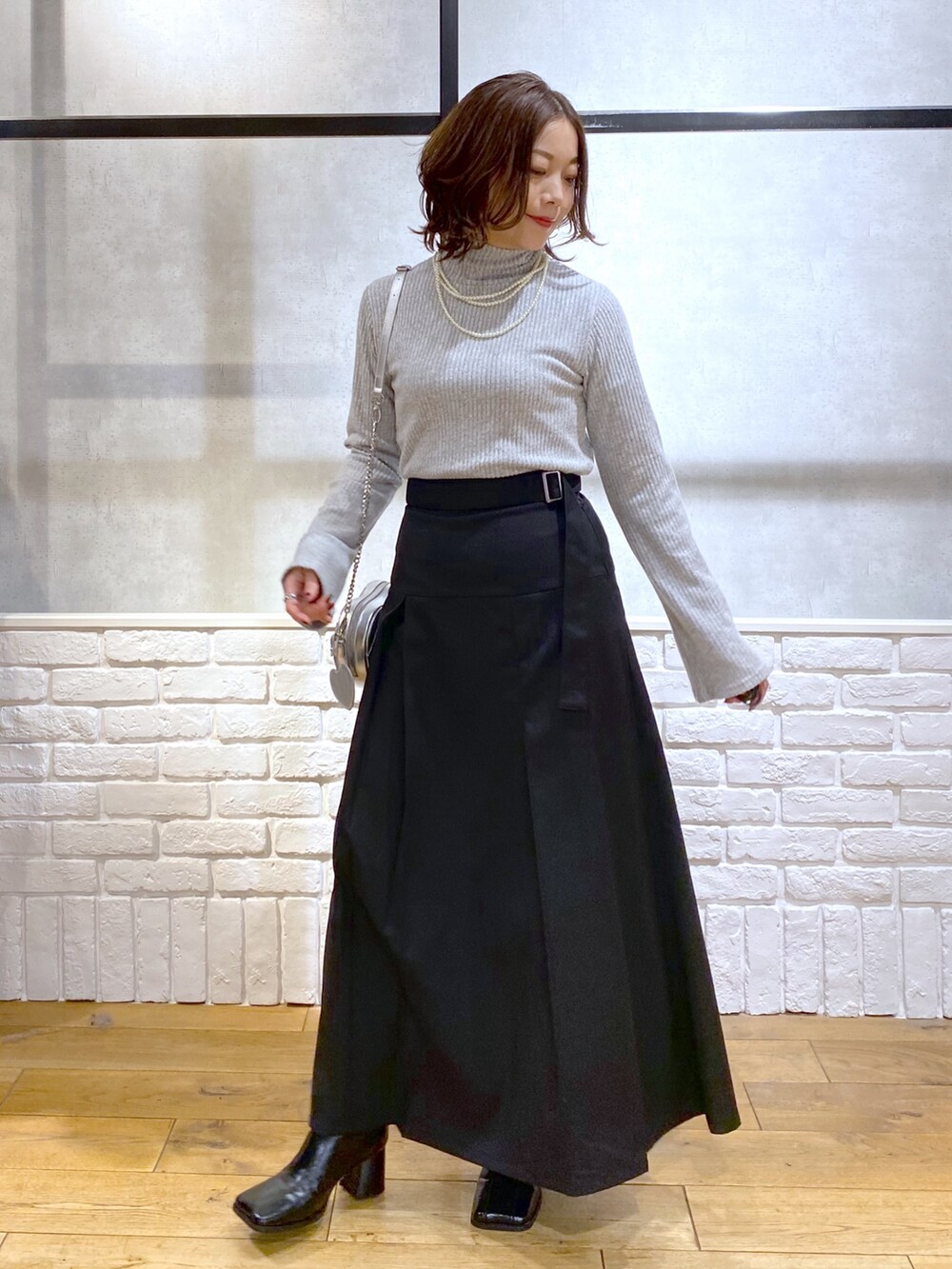 ブラウン系のテーラードジャケット、グレー系のTシャツ/カットソー、ブラック系のスカートを着用したレディースの冬コーディネートの3枚目の写真