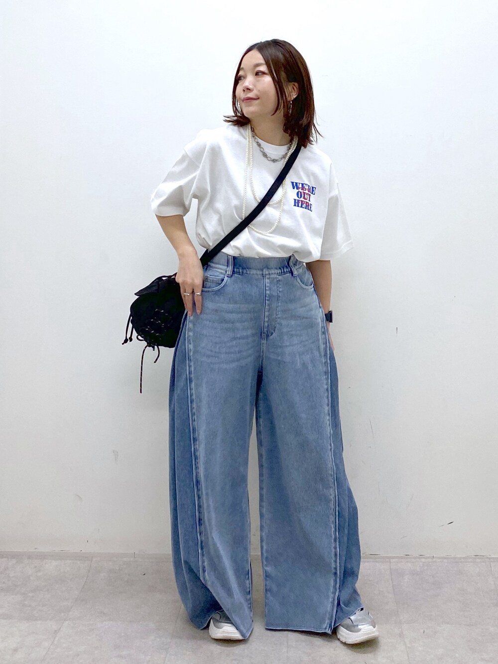 ホワイト系のTシャツ/カットソー、ブラック系のボディバッグ/ウエストポーチ、ブルー系のデニムパンツを着用したレディースの春コーディネートの9枚目の写真