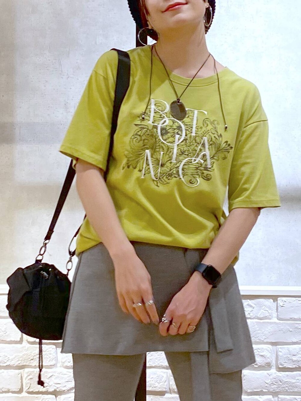 ホワイト系のサンダル、ブラック系のショルダーバッグ、グリーン系のTシャツ/カットソーを着用したレディースの夏コーディネートの2枚目の写真