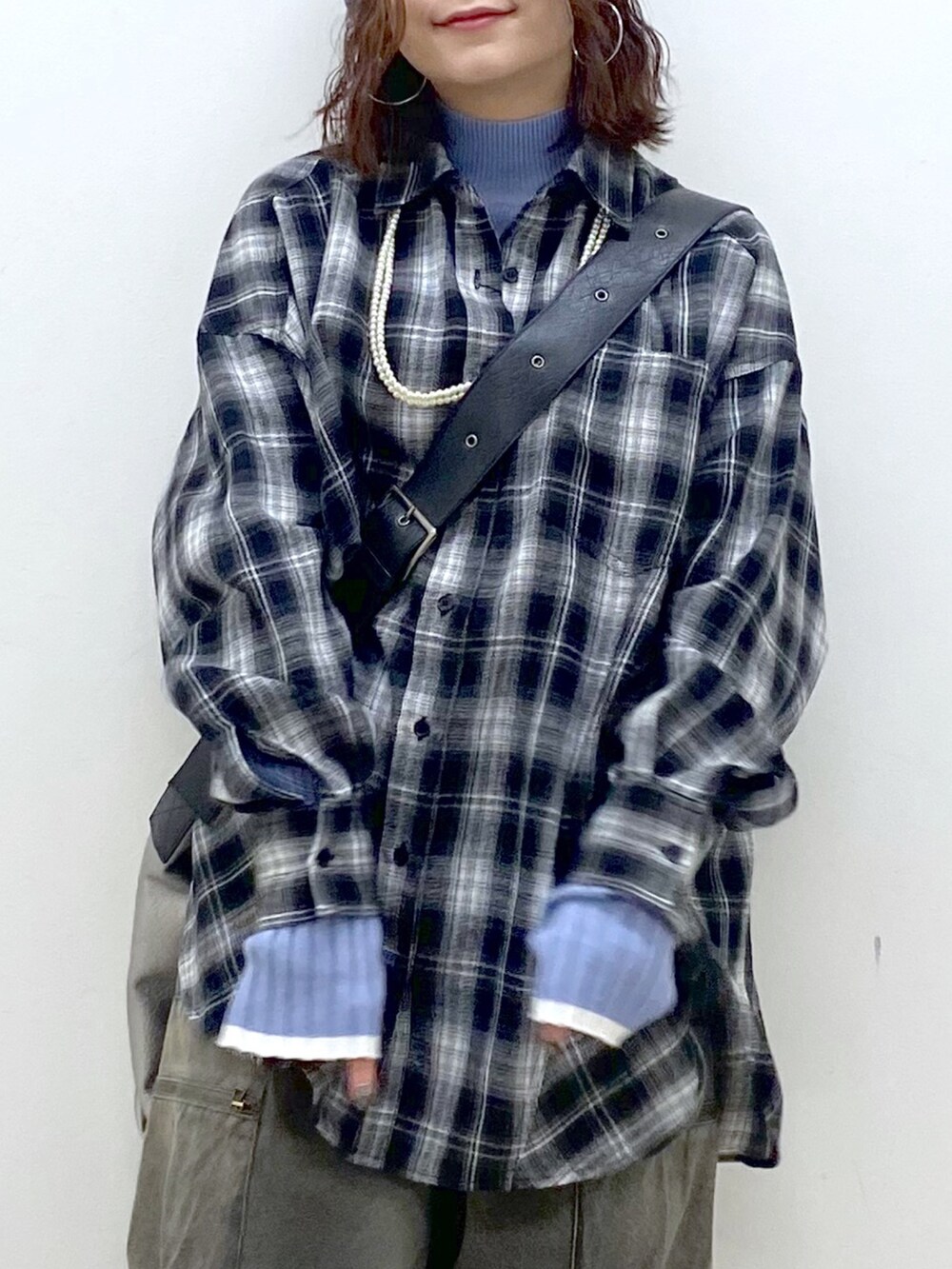 ブラック系のシャツ/ブラウス、シルバー系のトートバッグ、ブルー系のニット/セーターを着用したレディースの冬コーディネートの2枚目の写真