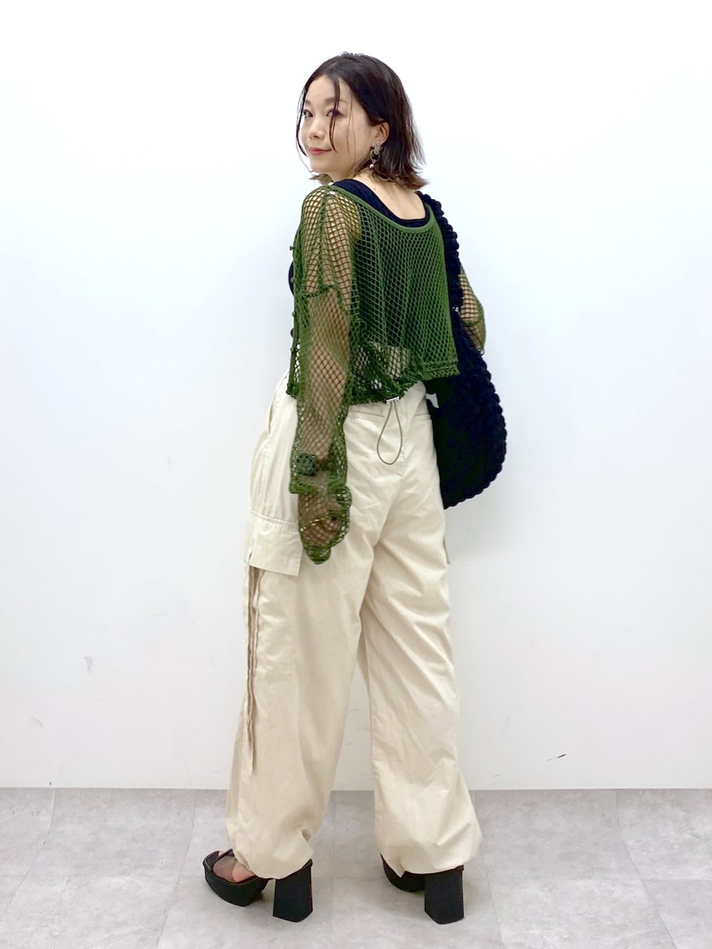 ホワイト系のカーゴパンツ、ブラック系のトップス、グリーン系のTシャツ/カットソーを着用したレディースの夏コーディネートの4枚目の写真