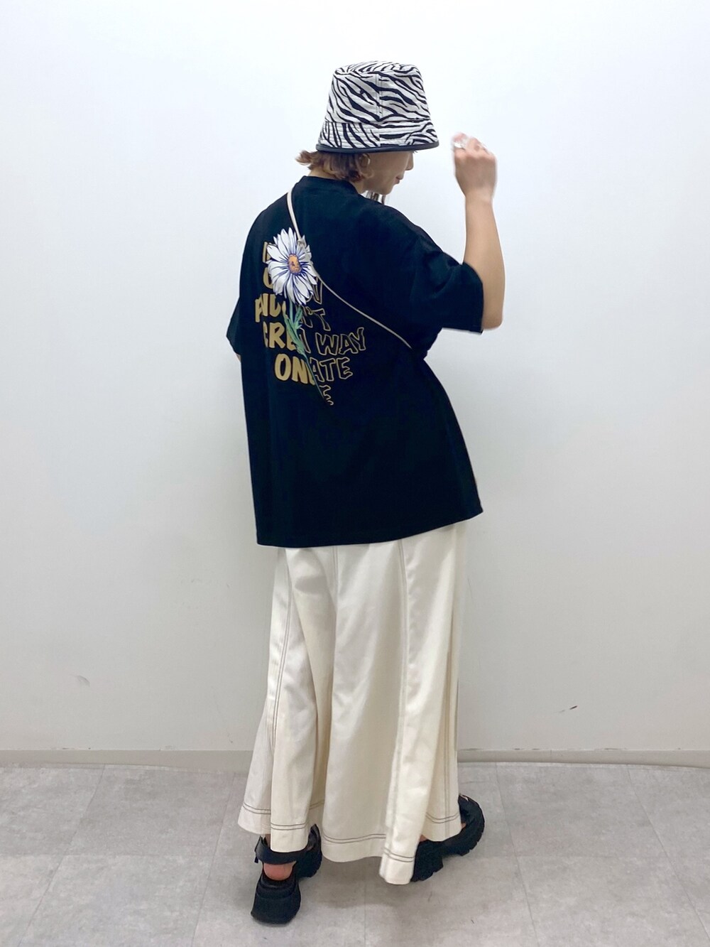 ベージュ系のショルダーバッグ、ブラック系のサンダル、ブラック系のTシャツ/カットソーを着用したレディースの夏コーディネートの2枚目の写真