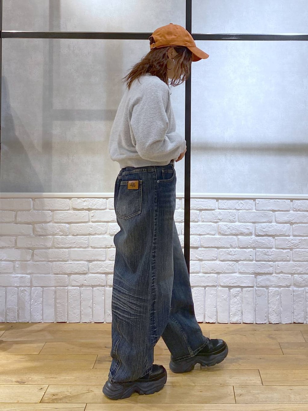 ブラック系のブーツ、ブルー系のデニムパンツ、その他のハンドバッグを着用したレディースの冬コーディネートの7枚目の写真