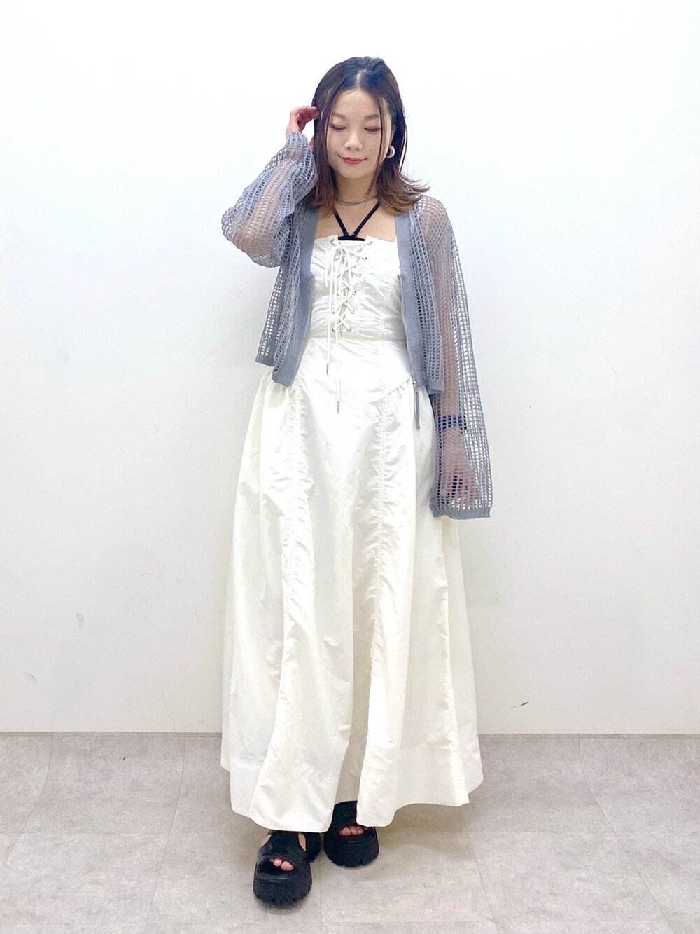 ホワイト系のワンピース、グレー系のカーディガン/ボレロ、ブラック系のサンダルを着用したレディースの春コーディネートの9枚目の写真