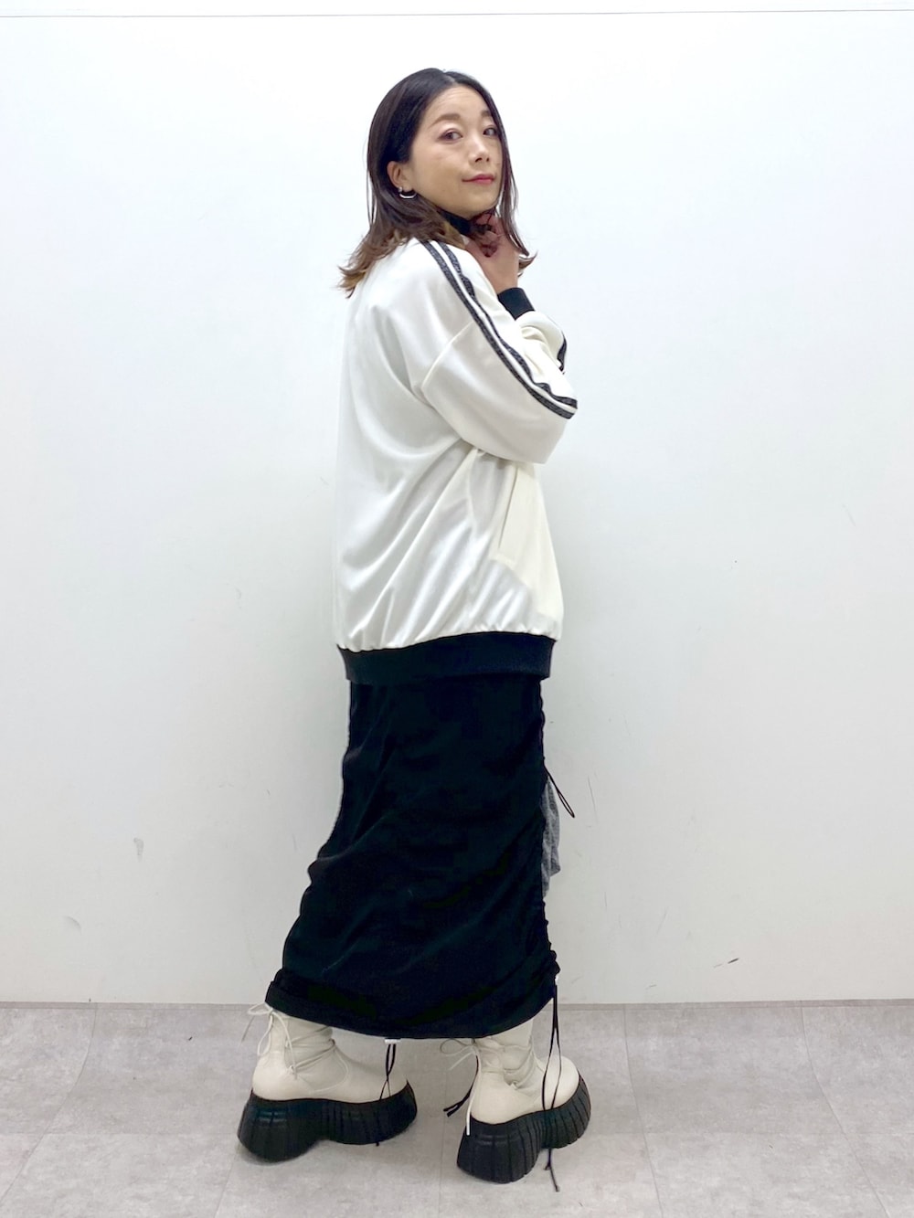 ブラック系のワンピース、ホワイト系のその他アウター、ブラック系のトートバッグを着用したレディースの冬コーディネートの2枚目の写真