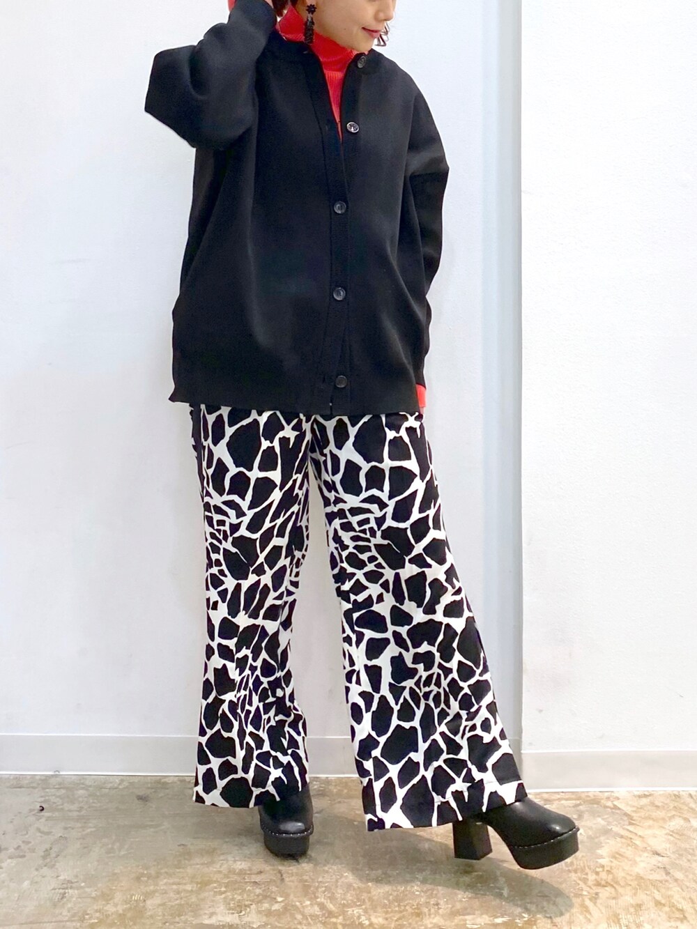 ブラック系のカーディガン/ボレロ、ピンク系のニット/セーター、ブラック系のブーツを着用したレディースの冬コーディネートの4枚目の写真