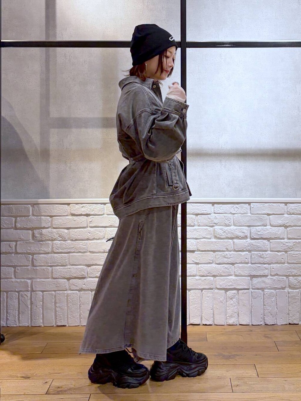 ブラック系のスニーカー、ブルー系のハンドバッグ、ブラック系のブルゾンを着用したレディースの冬コーディネートの4枚目の写真