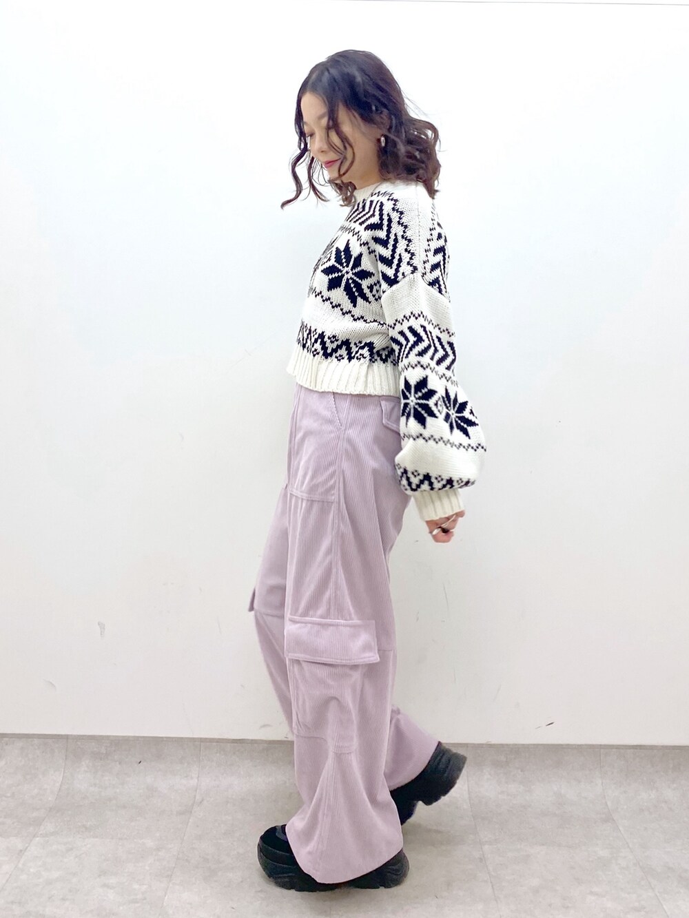 ピンク系のカーゴパンツ、ホワイト系のニット/セーター、シルバー系のショルダーバッグを着用したレディースの冬コーディネートの4枚目の写真
