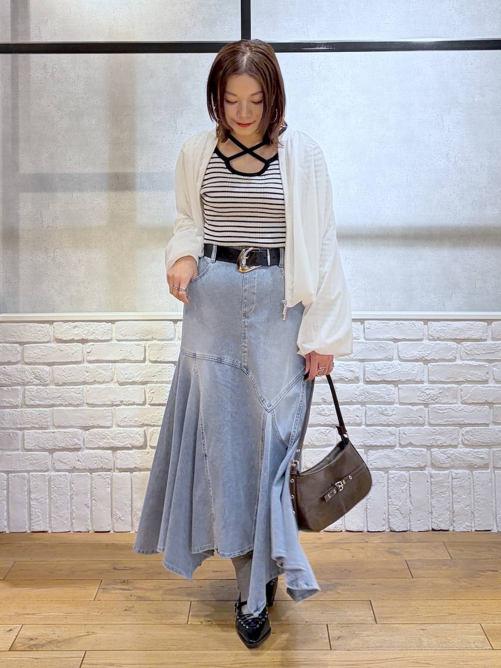 ブラウン系のハンドバッグ、ホワイト系のニット/セーター、ブラック系のサンダルを着用したレディースの春コーディネートの8枚目の写真