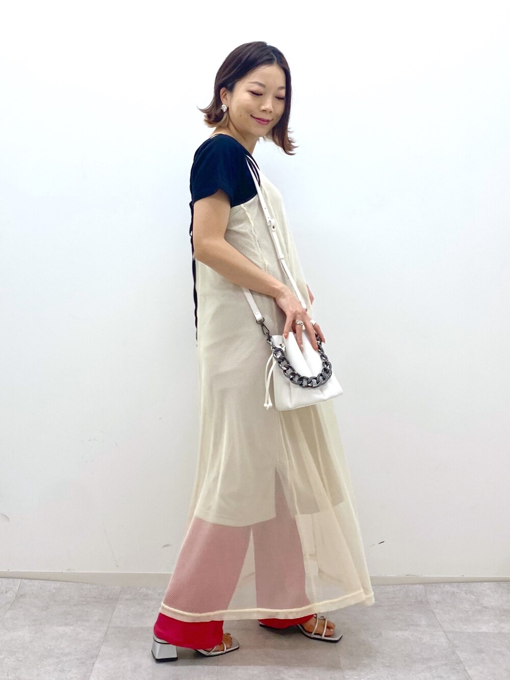ブラック系のTシャツ/カットソー、ベージュ系のワンピース、ホワイト系のショルダーバッグを着用したレディースの夏コーディネートの3枚目の写真
