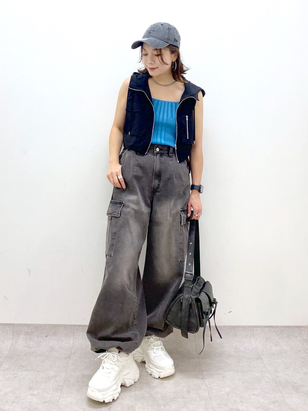 ブラウン系のデニムパンツ、ブラック系のショルダーバッグ、ホワイト系のスニーカーを着用したレディースの夏コーディネートの8枚目の写真
