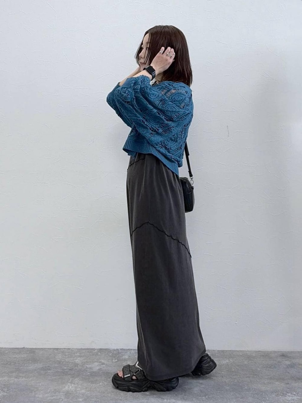 ブラック系のワンピース、ブルー系のカーディガン/ボレロ、ブラック系のボストンバッグを着用したレディースの春コーディネートの6枚目の写真