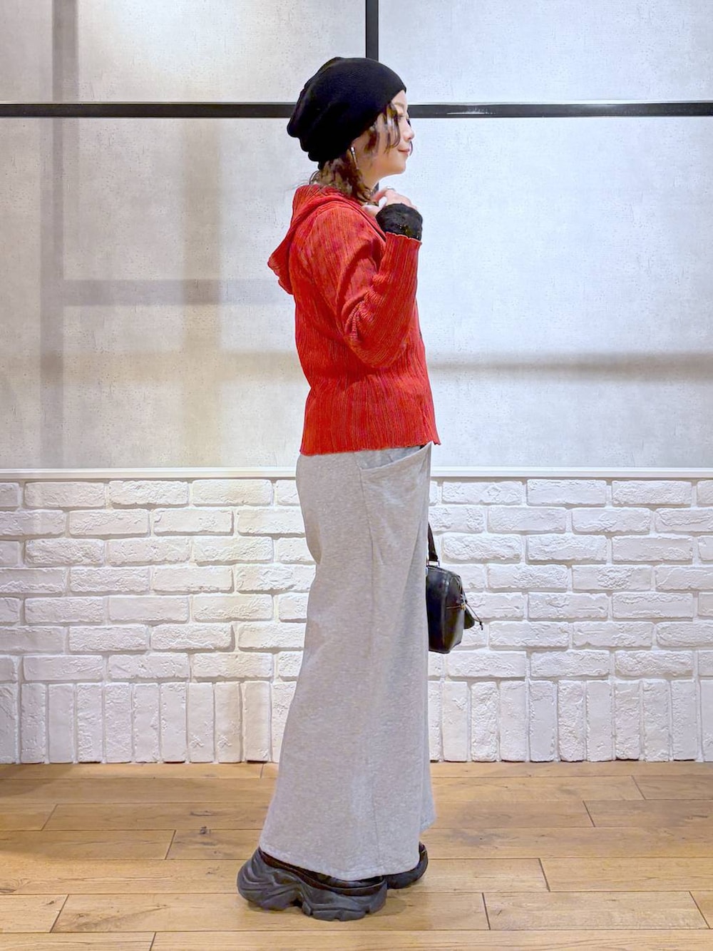 ブラック系のスニーカー、ブラック系のボストンバッグ、レッド系のカーディガン/ボレロを着用したレディースの春コーディネートの5枚目の写真