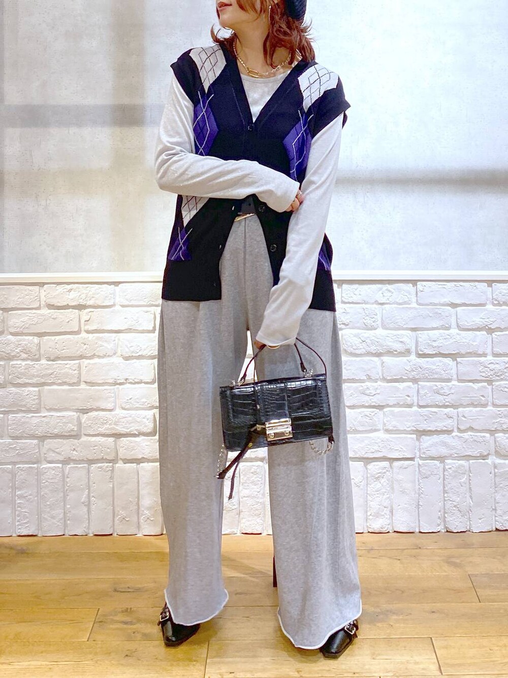 ブラック系のパンプス、グレー系のスウェットパンツ、ブラック系のハンドバッグを着用したレディースの秋コーディネートの2枚目の写真