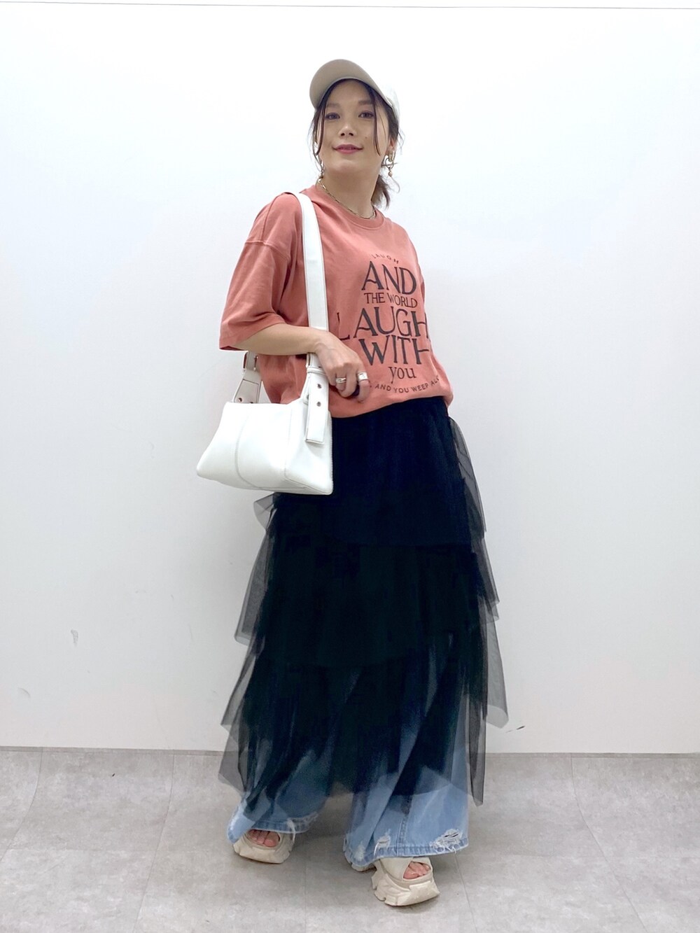 ブルー系のデニムパンツ、オレンジ系のTシャツ/カットソー、ブラック系のスカートを着用したレディースの夏コーディネートの8枚目の写真