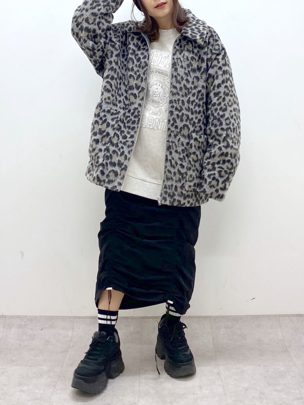 ベージュ系のスウェット、ブラック系のワンピース、ブラック系のスニーカーを着用したレディースの冬コーディネートの6枚目の写真