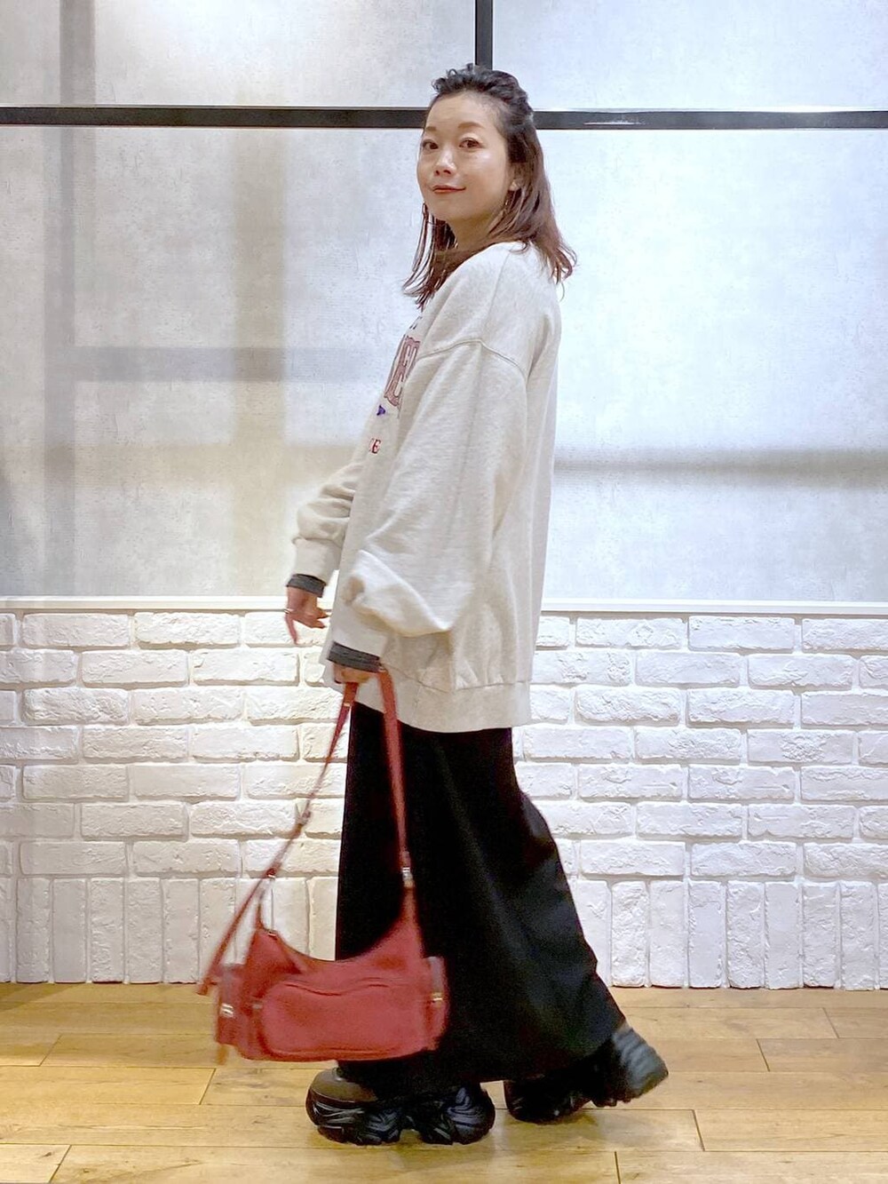 ブラウン系のブーツ、シルバー系のTシャツ/カットソー、ベージュ系のスウェットを着用したレディースの冬コーディネートの5枚目の写真