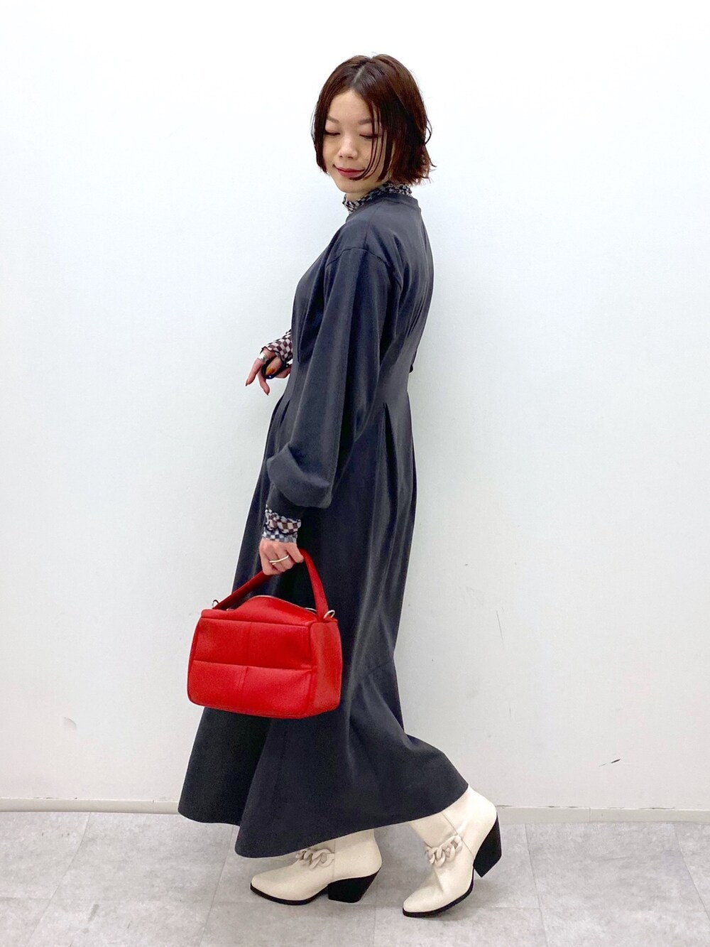 ブラック系のワンピース/ドレス、その他のその他トップス、レッド系のショルダーバッグを着用したレディースの秋コーディネートの2枚目の写真