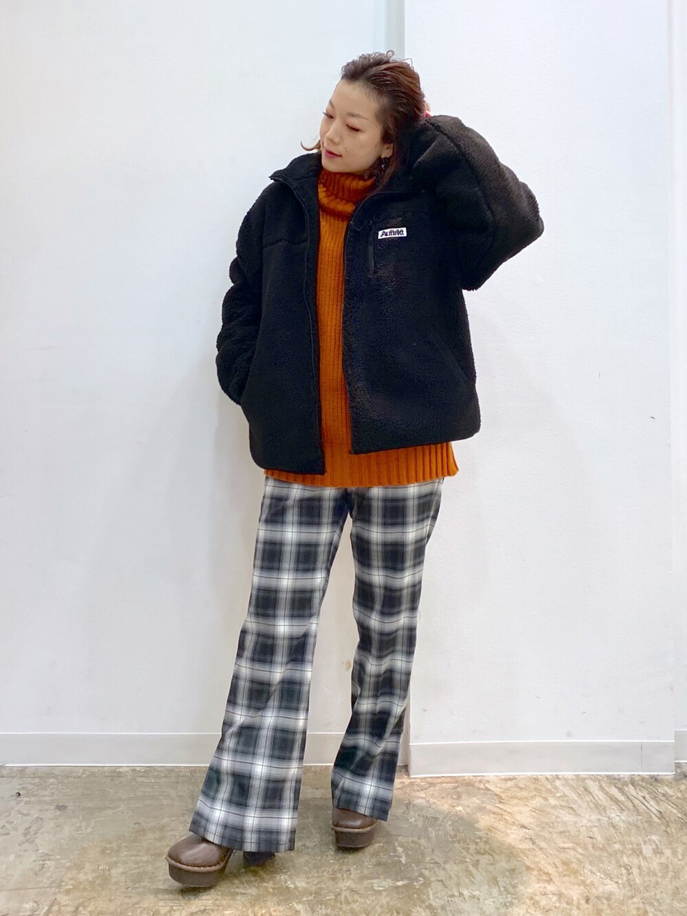 ブラック系のその他パンツ、ブラウン系のブーツ、オレンジ系のニット/セーターを着用したレディースの冬コーディネートの4枚目の写真