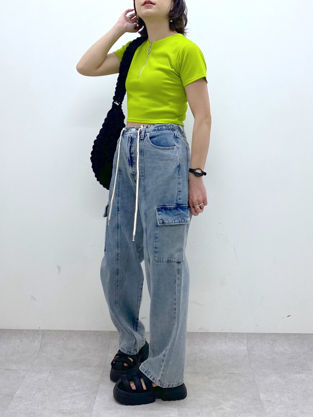 ブルー系のデニムパンツ、ブラック系のバッグ、イエロー系のTシャツ/カットソーを着用したレディースの春コーディネートの5枚目の写真