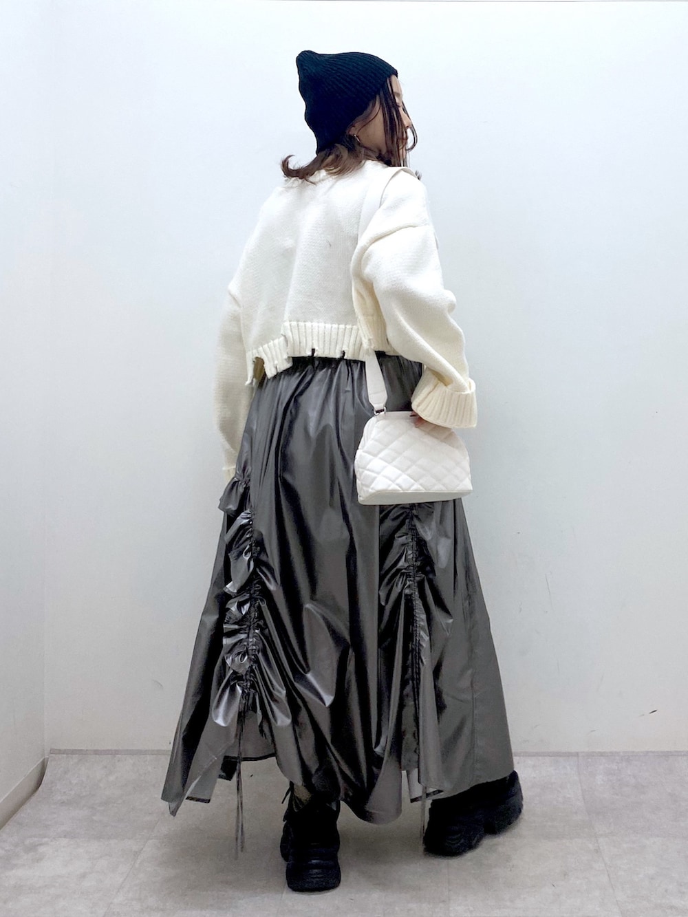 ホワイト系のニット/セーター、シルバー系のスカート、ホワイト系のショルダーバッグを着用したレディースの冬コーディネートの5枚目の写真