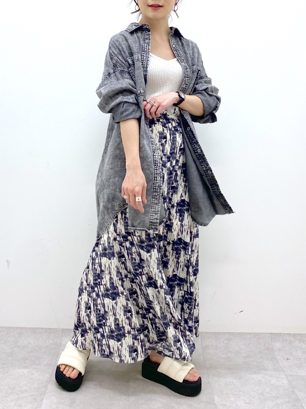 ブラック系のトップス、ブラック系のスカート、ホワイト系のトップスを着用したレディースの春コーディネートの4枚目の写真