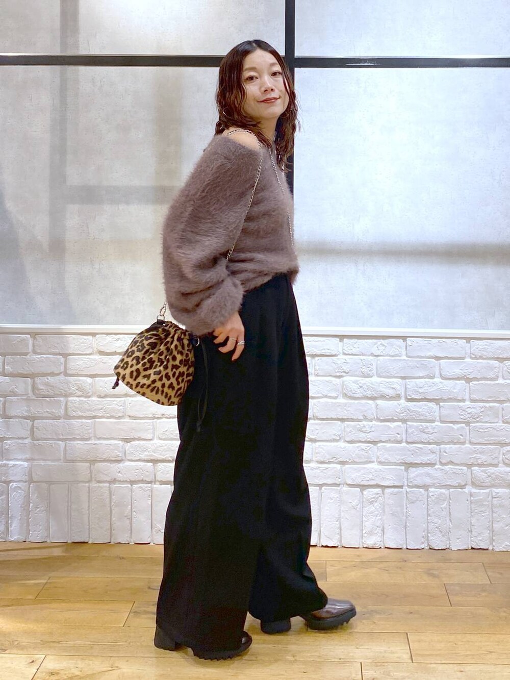 その他のブーツ、ブラック系のスラックス、ブラウン系のニット/セーターを着用したレディースの秋コーディネートの7枚目の写真