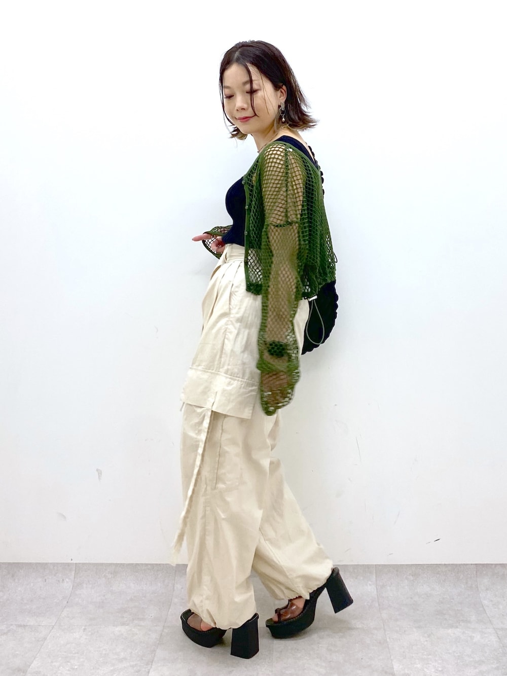 ホワイト系のカーゴパンツ、ブラック系のトップス、グリーン系のTシャツ/カットソーを着用したレディースの夏コーディネートの5枚目の写真