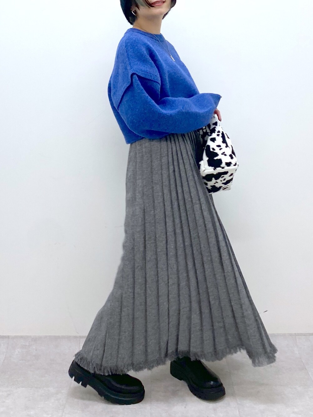 ブルー系のトップス、ブラック系のスカート、ブラック系のシューズを着用したレディースの秋コーディネートの4枚目の写真