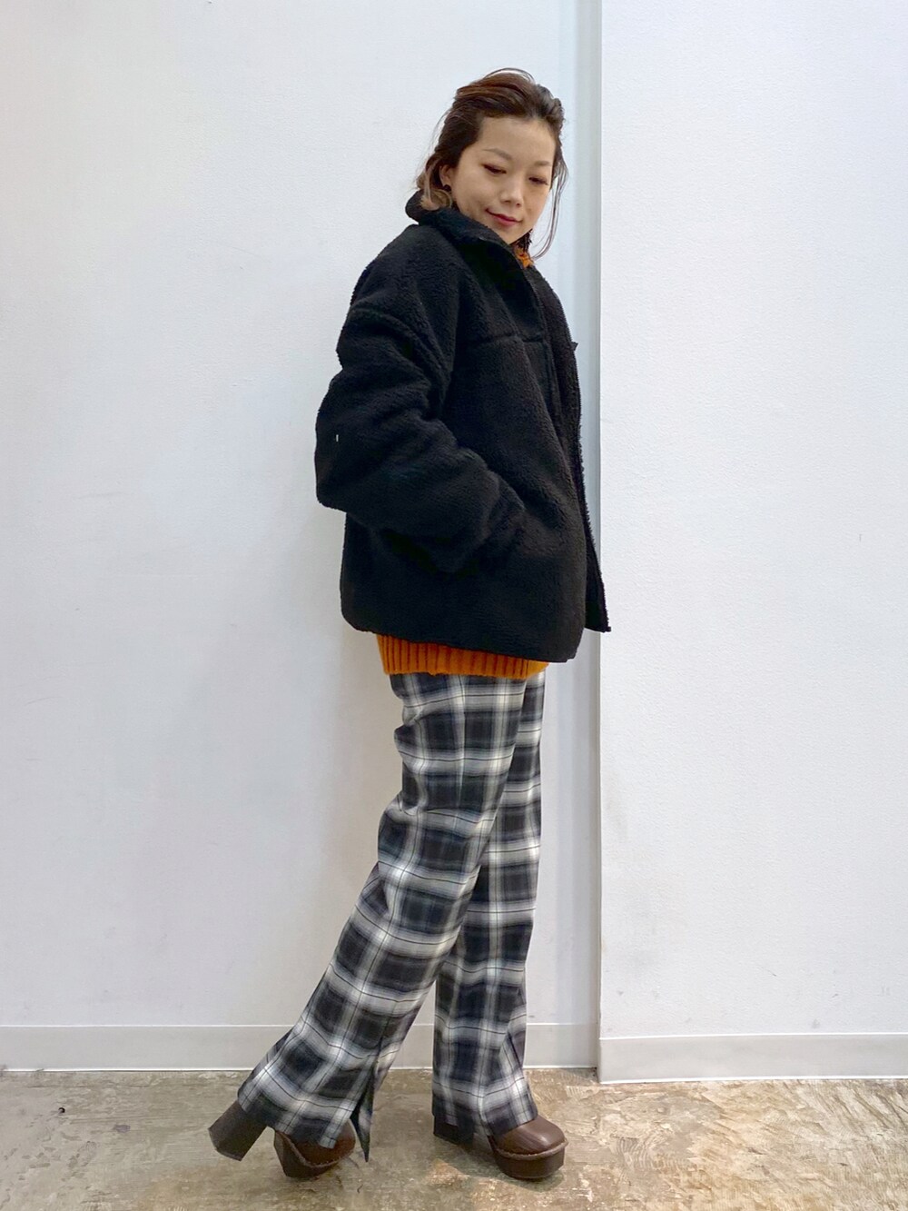 ブラック系のその他パンツ、ブラウン系のブーツ、オレンジ系のニット/セーターを着用したレディースの冬コーディネートの3枚目の写真