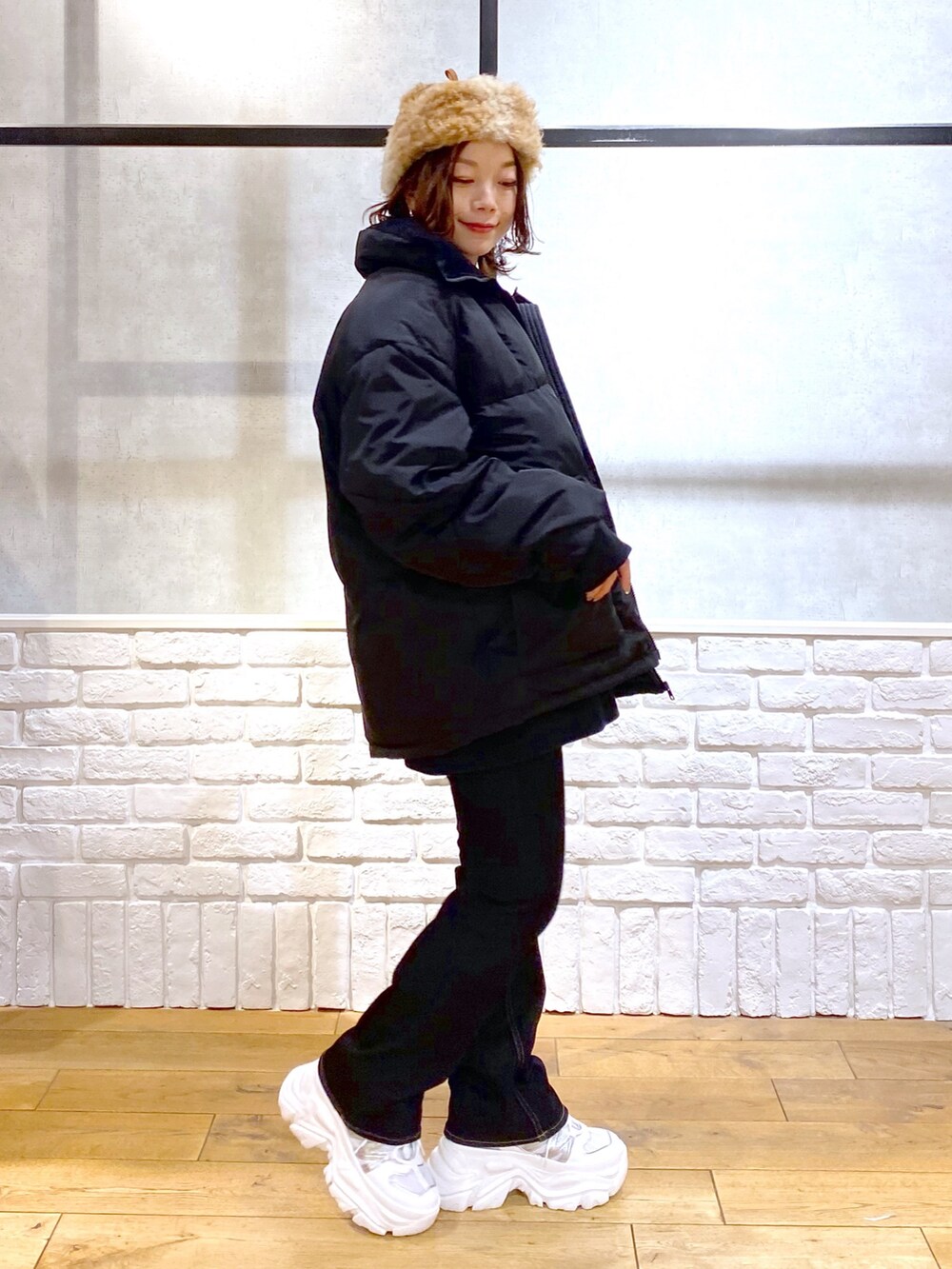 ブルー系のニット/セーター、ブラック系のブルゾン、ブルー系のデニムパンツを着用したレディースの冬コーディネートの5枚目の写真