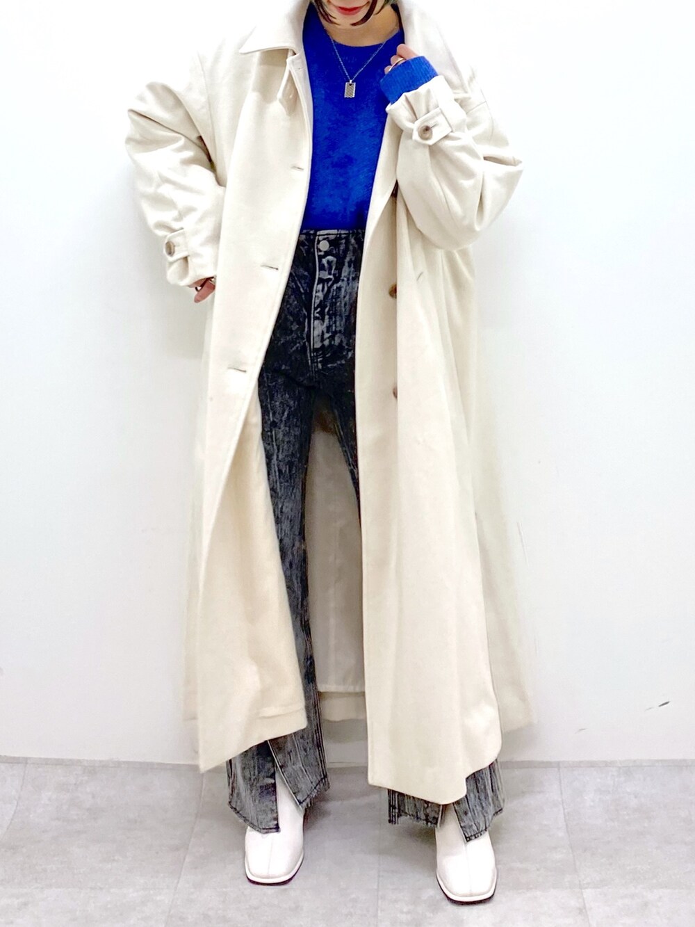 ブルー系のトップス、ブラック系のデニムパンツ、ホワイト系のジャケット/アウターを着用したレディースの秋コーディネートの5枚目の写真