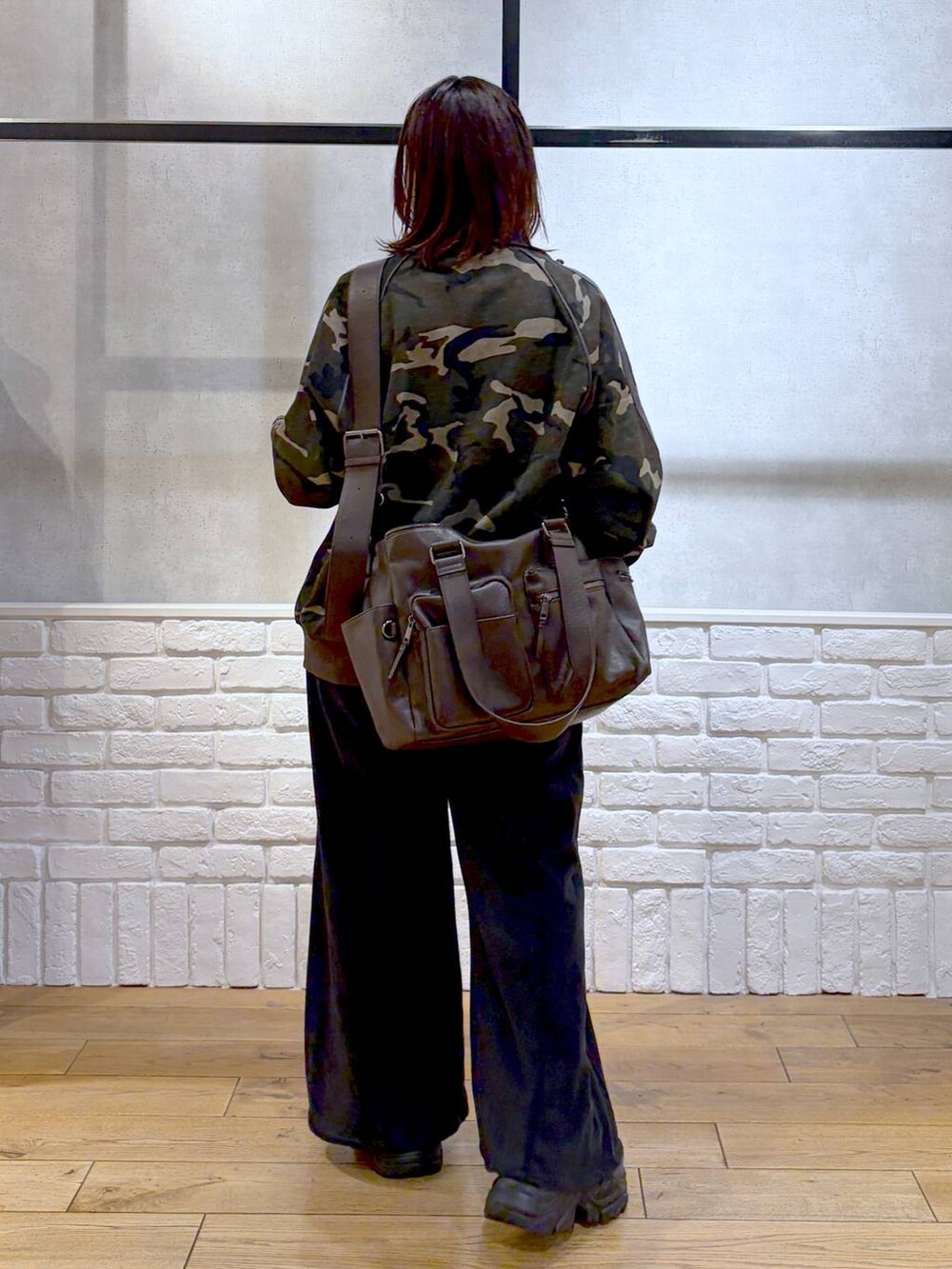 グレー系のスニーカー、ブラウン系のボストンバッグ、イエロー系のニット/セーターを着用したレディースの冬コーディネートの5枚目の写真