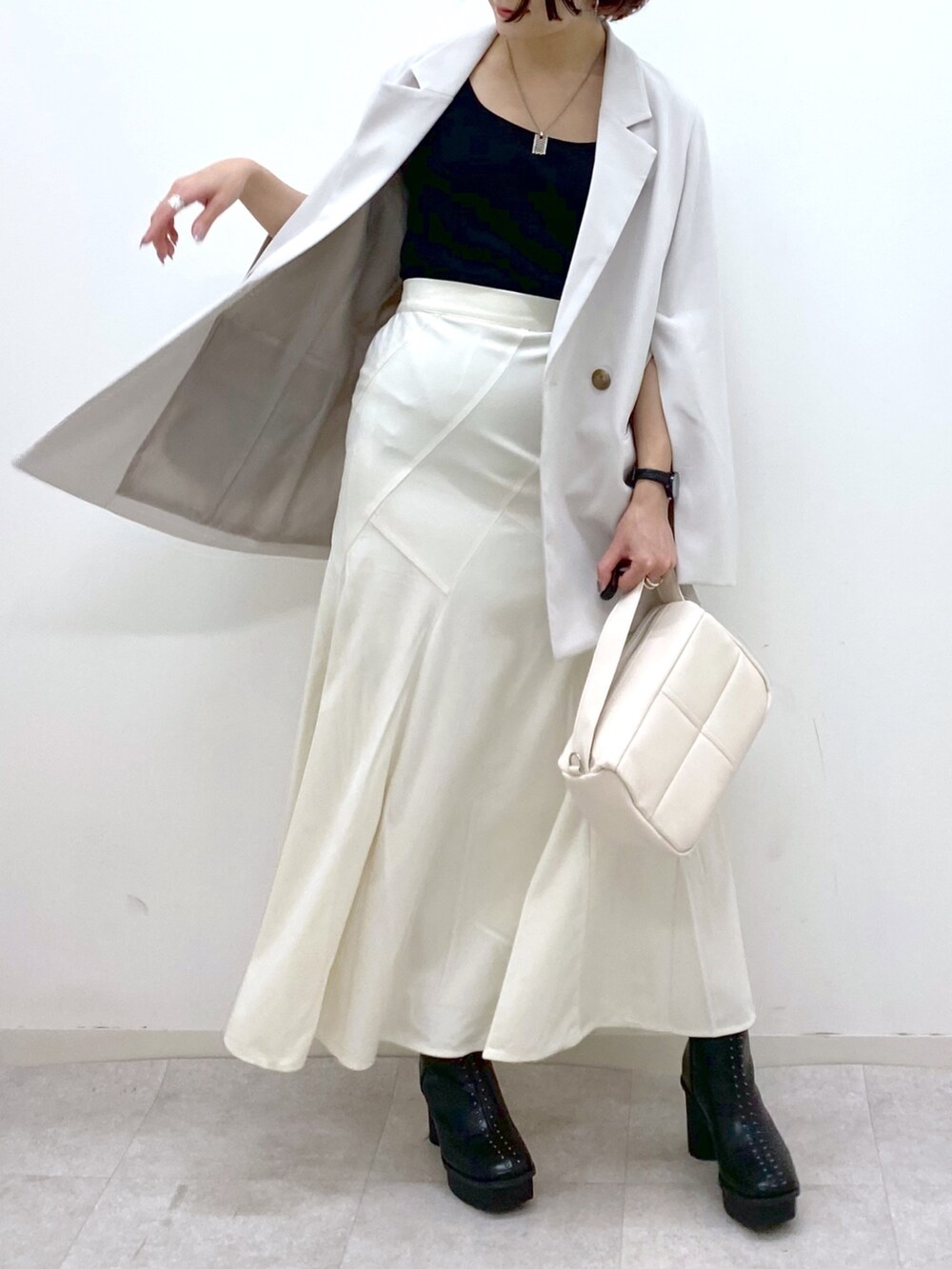 ホワイト系のショルダーバッグ、ホワイト系のスカート、ベージュ系のテーラードジャケットを着用したレディースの秋コーディネートの4枚目の写真