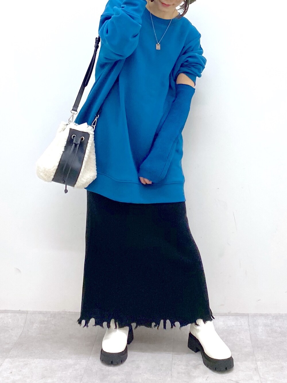 ホワイト系のバッグ、ホワイト系のシューズ、ブラック系のスカートを着用したレディースの冬コーディネートの4枚目の写真