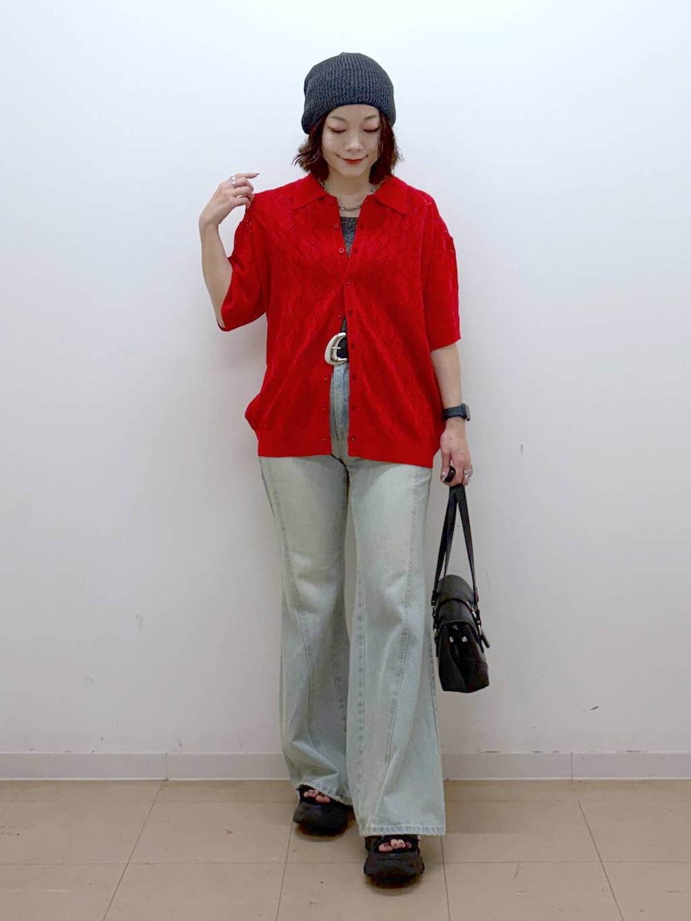 レッド系のポロシャツ、ブルー系のデニムパンツ、ブラック系のサンダルを着用したレディースの夏コーディネートの9枚目の写真