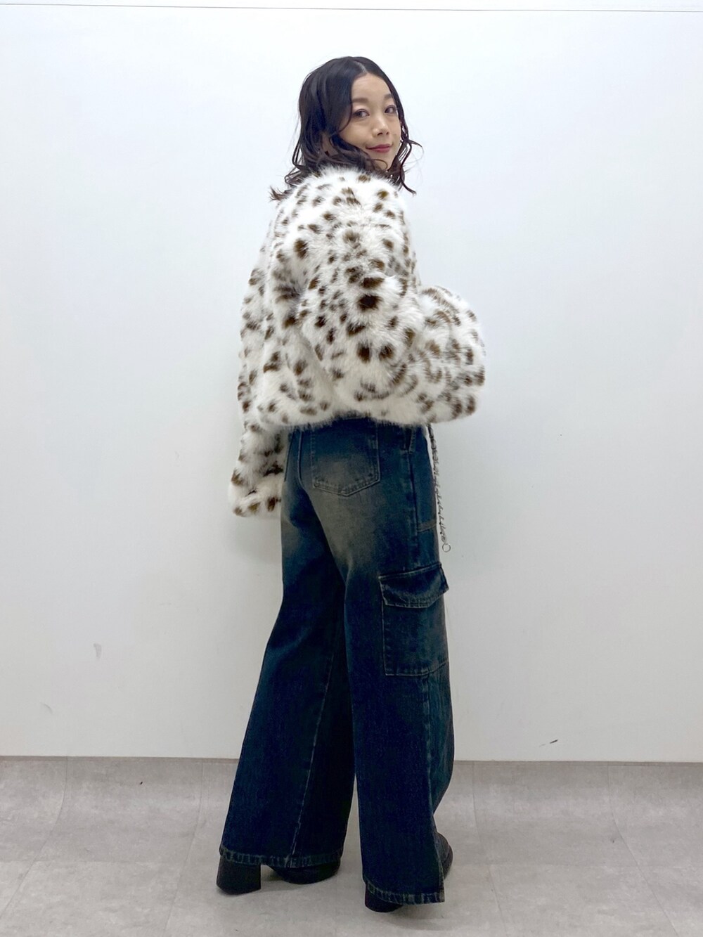 ブルー系のデニムパンツ、ブルー系のニット/セーター、ブラック系のブーツを着用したレディースの冬コーディネートの5枚目の写真