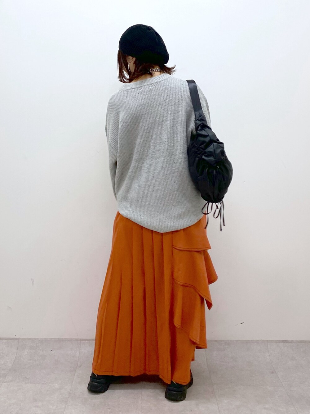 グレー系のニット/セーター、オレンジ系のスカート、ブラック系のローファーを着用したレディースの冬コーディネートの6枚目の写真