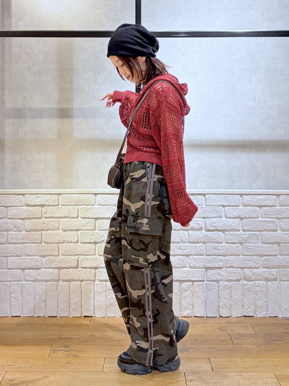 ブラック系のスニーカー、ブラック系のタンクトップ、グリーン系のスウェットパンツを着用したレディースの春コーディネートの7枚目の写真