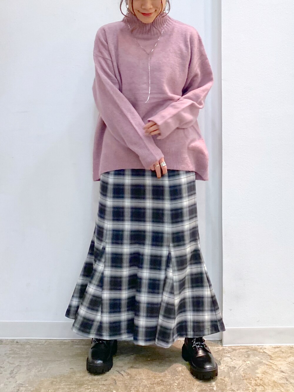 ピンク系のニット/セーター、ブラック系のスカート、ブラック系のブーツを着用したレディースの冬コーディネートの3枚目の写真