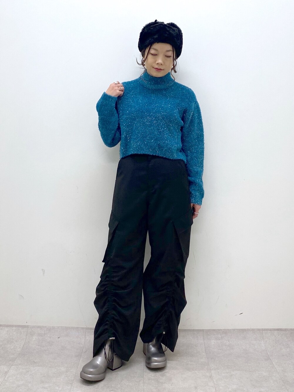 ブルー系のニット/セーター、ブラック系のその他パンツ、その他のブーツを着用したレディースの冬コーディネートの7枚目の写真