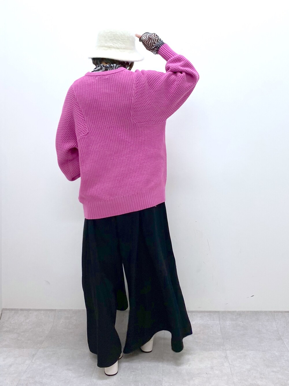 ピンク系のニット/セーター、ブラック系のスラックス、ブラック系のトップスを着用したレディースの冬コーディネートの3枚目の写真