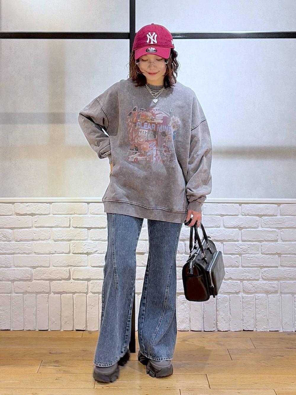 グレー系のスニーカー、ブルー系のデニムパンツ、ブラック系のショルダーバッグを着用したレディースの冬コーディネートの8枚目の写真