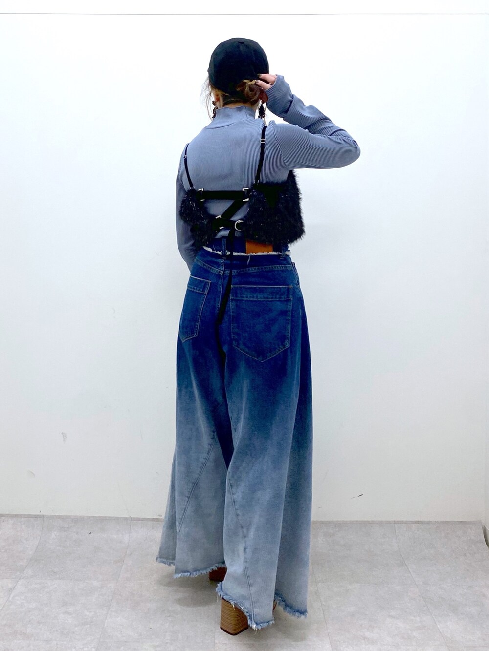 ブルー系のデニムパンツ、ブラック系のベスト、ブルー系のTシャツ/カットソーを着用したレディースの秋コーディネートの4枚目の写真