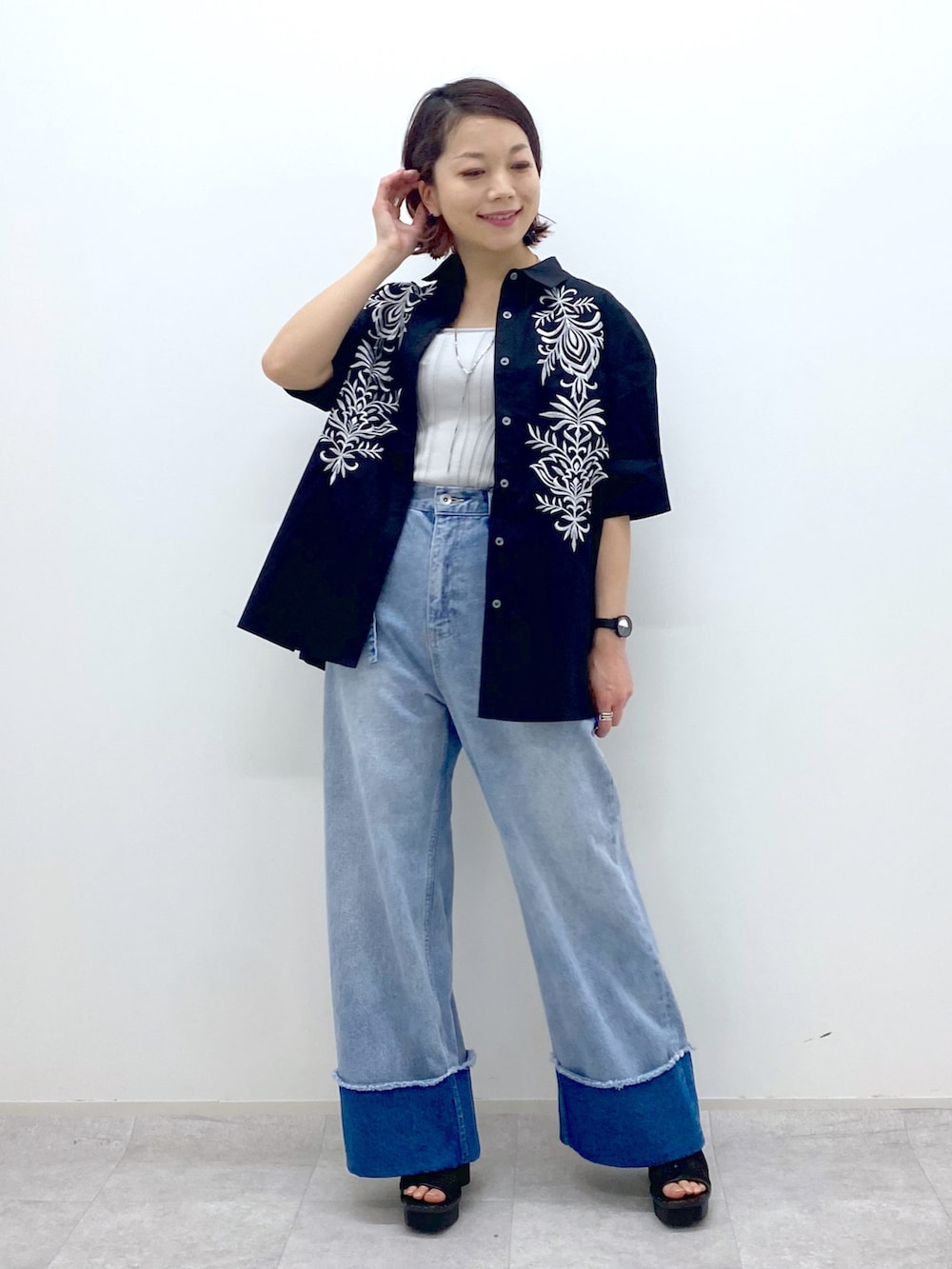 ブルー系のデニムパンツ、ブラック系のシャツ/ブラウス、ベージュ系のタンクトップを着用したレディースの春コーディネートの2枚目の写真