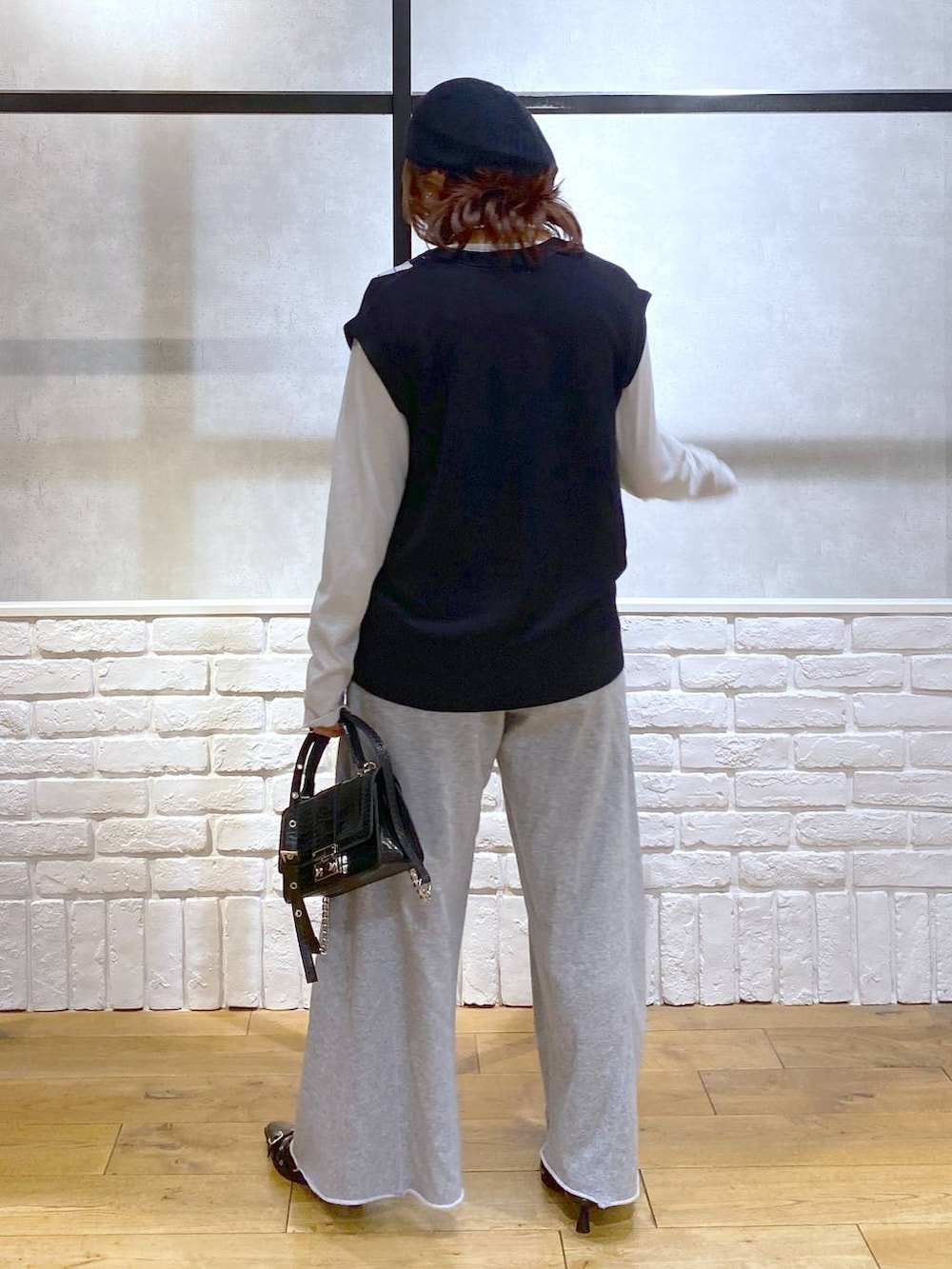 ブラック系のパンプス、グレー系のスウェットパンツ、ブラック系のハンドバッグを着用したレディースの秋コーディネートの6枚目の写真