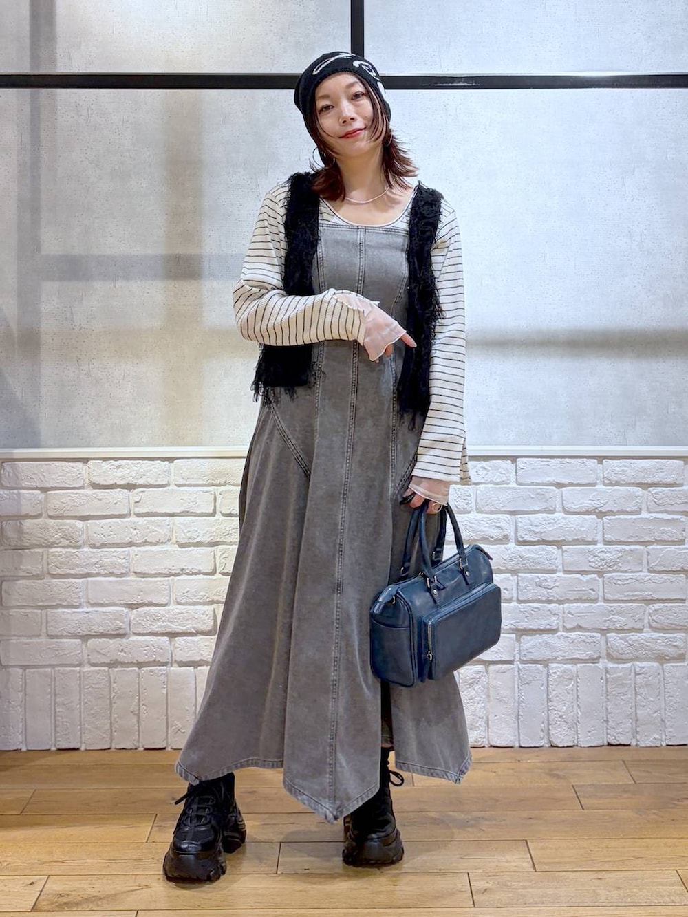 ブラック系のスニーカー、ブラック系のワンピース、ブルー系のショルダーバッグを着用したレディースの冬コーディネートの8枚目の写真