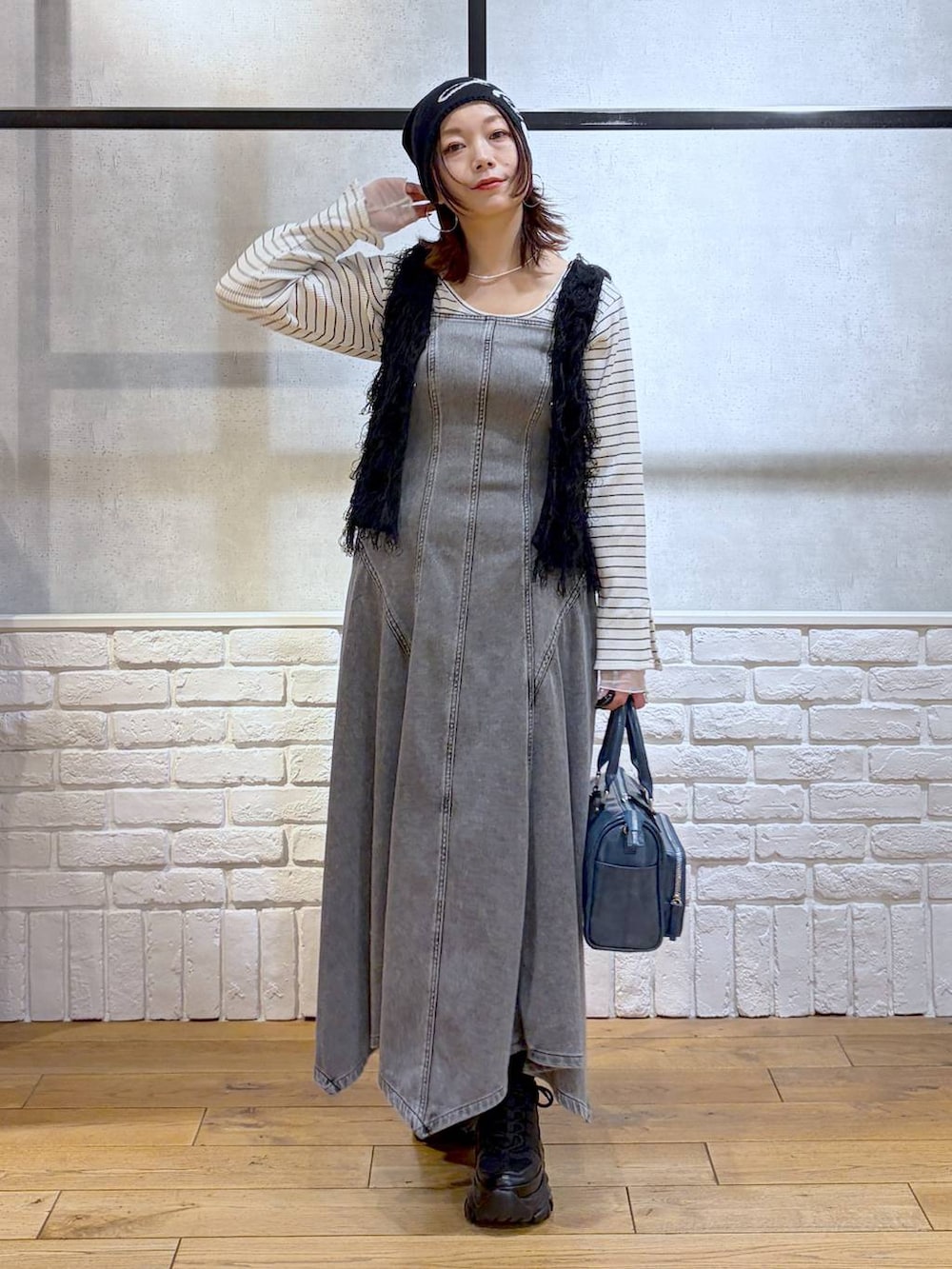 ブラック系のスニーカー、ブラック系のワンピース、ブルー系のショルダーバッグを着用したレディースの冬コーディネートの9枚目の写真