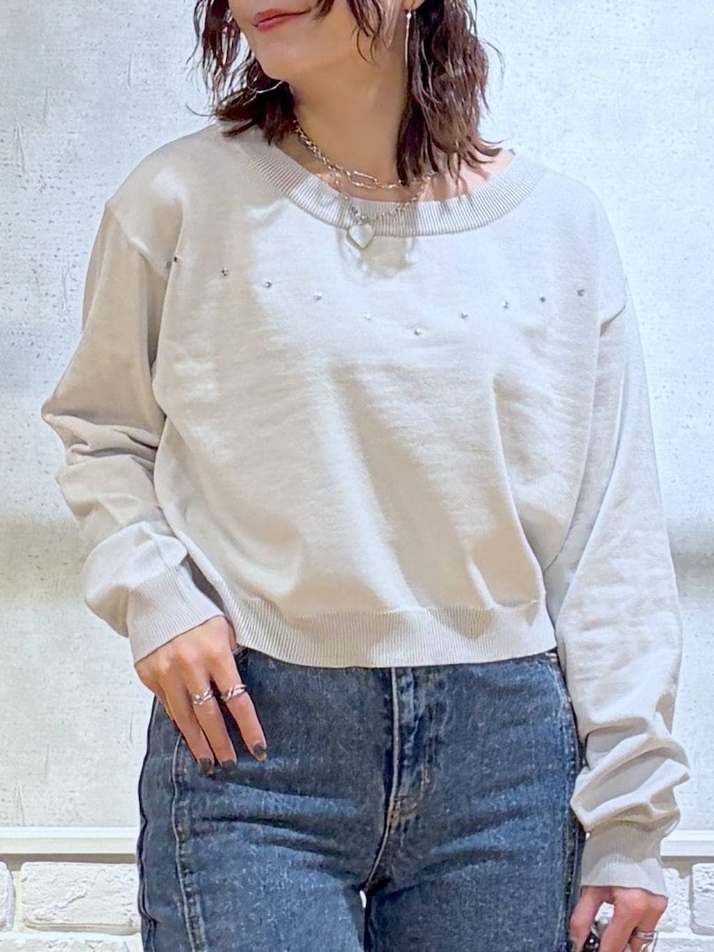 グレー系のスニーカー、ブルー系のデニムパンツ、ピンク系のハンドバッグを着用したレディースの冬コーディネートの2枚目の写真